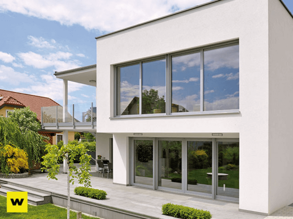Modernes Einfamilienhaus mit großer Fensterfront, Terrasse und gepflegtem Garten.