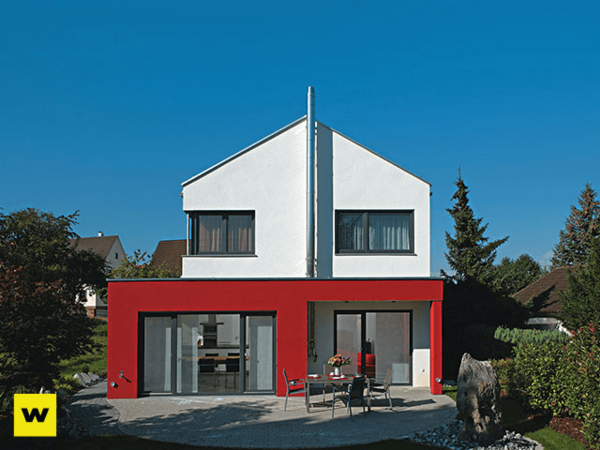 Modernes Einfamilienhaus mit roter Fassade und Garten, energieeffiziente Bauweise.
